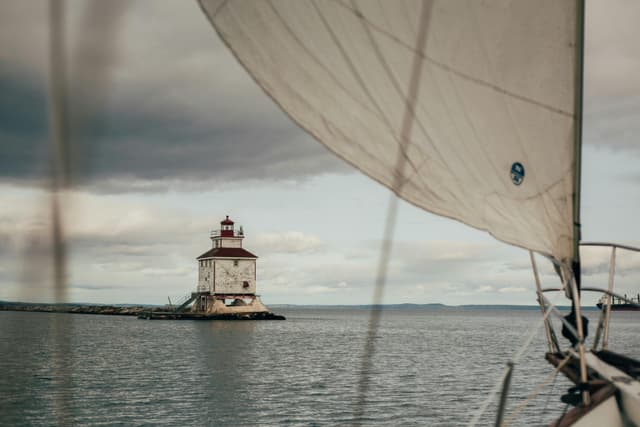 View from a sailboat near Thunder Bay Lighthouse on a cloudy day.