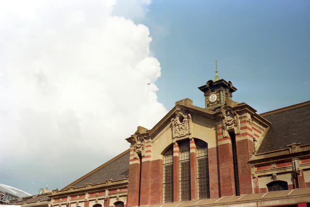 Low angle view of the historic Taichung Train Station, featuring classic architecture against a cloudy sky.