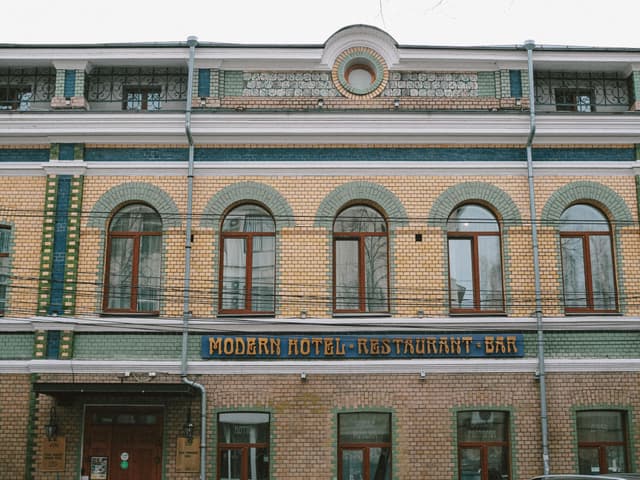 Historic building facade with arched windows and 'Modern Hotel Restaurant Bar' sign.