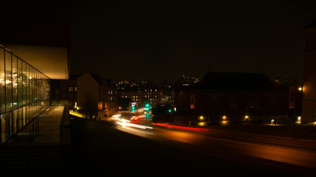 Long exposure of car light trails on a road in Aarhus during nighttime, capturing urban illumination.