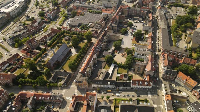 Aerial view of Horsens, Denmark shows urban architecture, roads, and greenery.