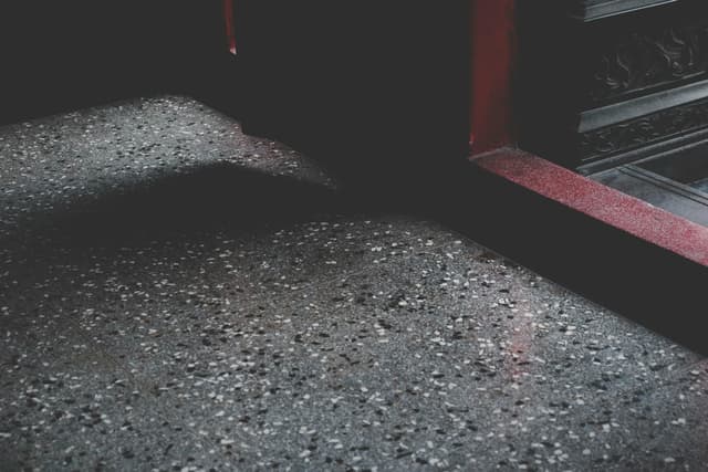 Close-up of a moody stone floor with shadows and texture in a Taiwanese building.
