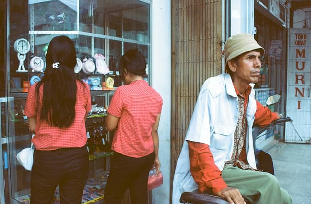 Casual street scene in Way Halim with two women at store and a man in front, capturing daily life.
