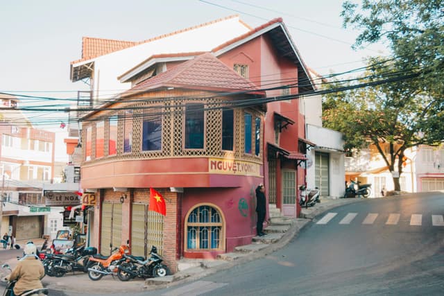Vibrant street scene showcasing Vietnamese architecture with motorcycles and a flag.