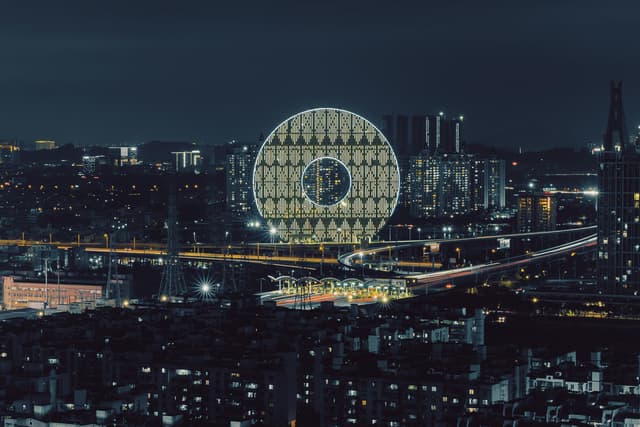 Night view of the illuminated Guangzhou Circle, a modern architectural landmark in China.