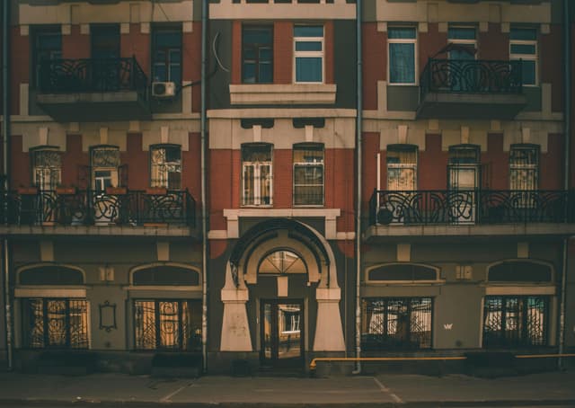 Vintage urban building facade showcasing detailed architecture and ornate balconies at sunset.