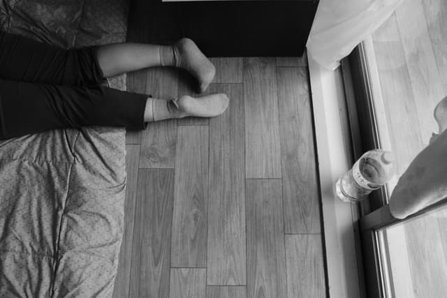 Black and white photo of relaxed legs near window in a Ulsan apartment.