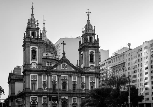 Black and white photo of a historic cathedral in Rio de Janeiro, Brazil, surrounded by city buildings.