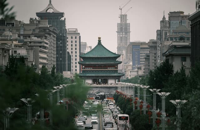 Aerial view of Xi'an with its iconic Bell Tower amidst city traffic, showcasing a blend of history and urban life.