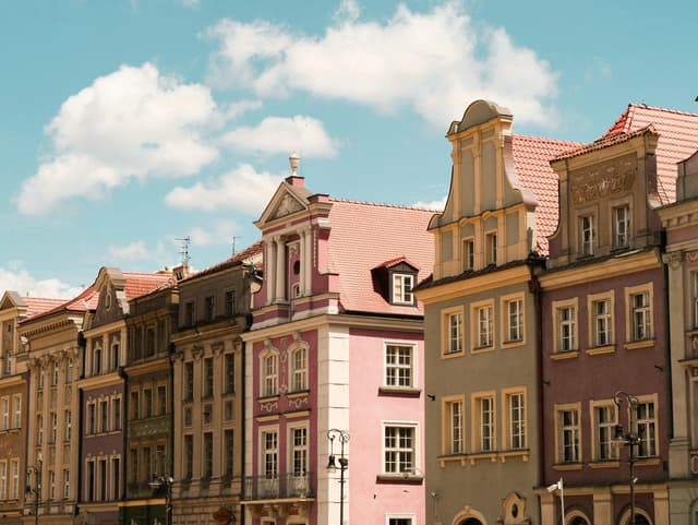 Colorful historic facades in Poznań, Poland under a bright blue sky.