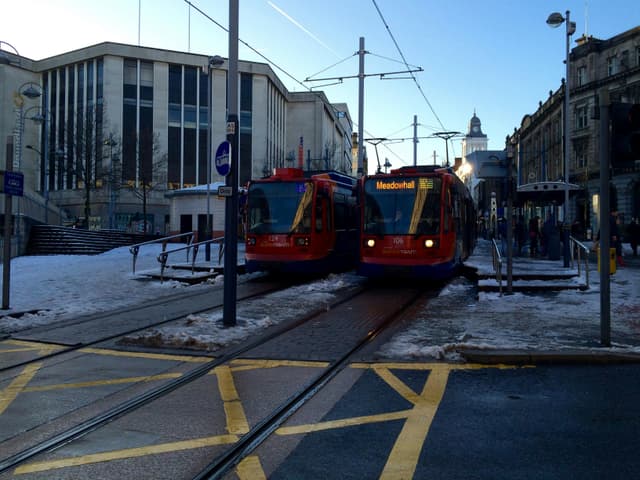 Street view of trams in Sheffield during winter, showcasing urban public transportation.