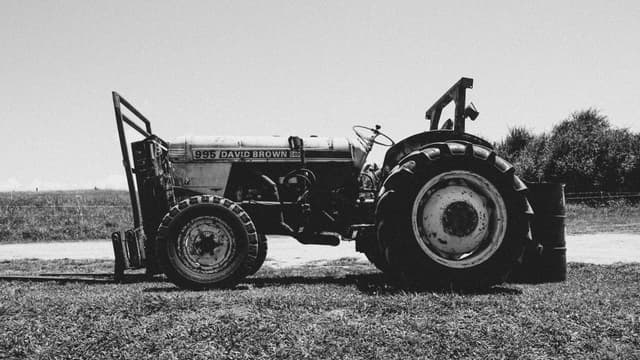 Black and white photo of a vintage tractor in Tauranga's countryside, New Zealand.