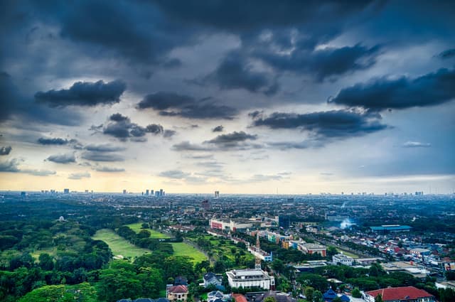 A captivating aerial view of Tangerang, Indonesia, showcasing urban architecture and lush greenery under a dramatic sky.
