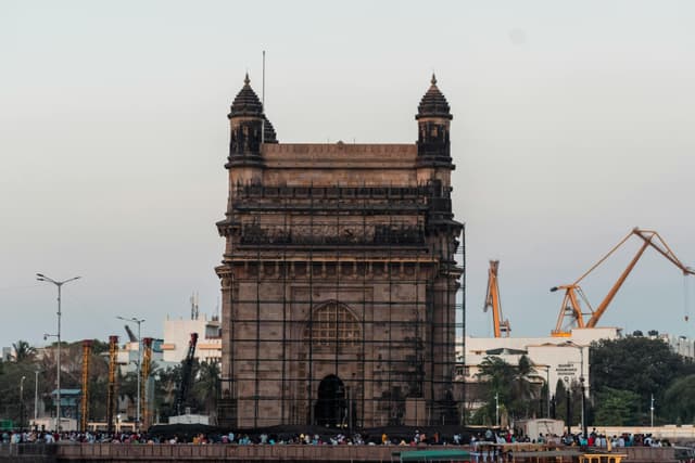Iconic Gateway of India monument in Mumbai, a popular tourist attraction, captured at dusk.