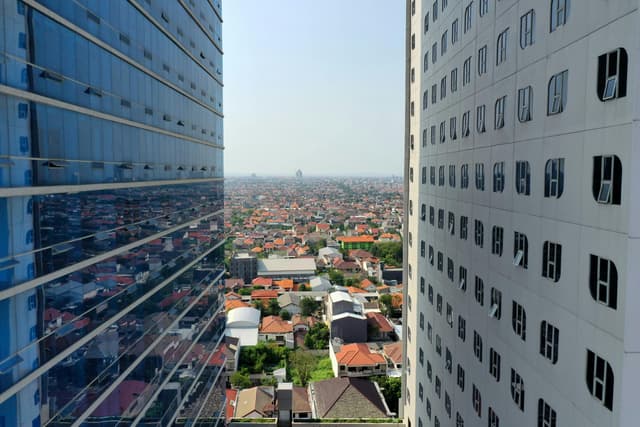 Explore the modern skyline of Surabaya between towering skyscrapers in this stunning aerial view.