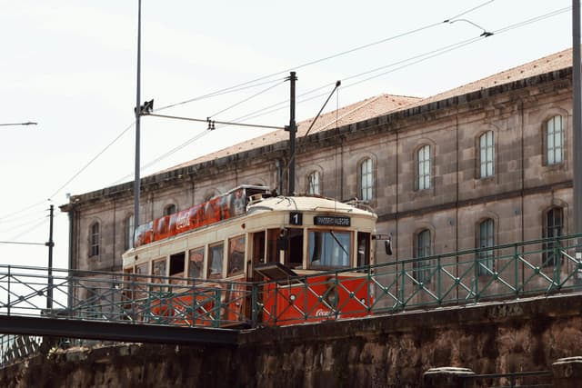 Vintage red tram in Porto, Portugal showcases historic architecture and transportation.