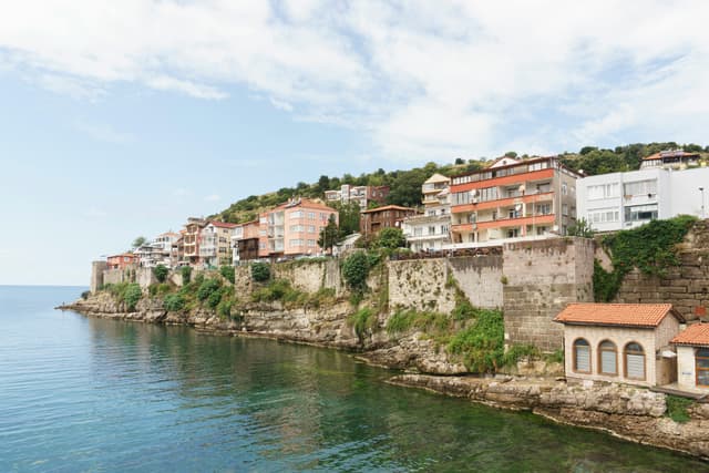 Picturesque seaside town of Amasra, Türkiye with colorful buildings on rugged cliffs.