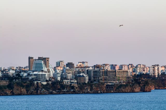Stunning view of Antalya skyline at dusk, with buildings along the coast and a serene sea.