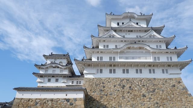 Stunning view of Himeji Castle's traditional architecture against a clear blue sky in Japan.