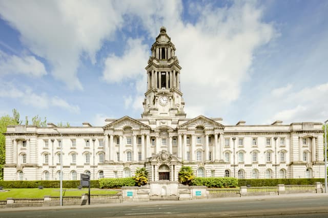 Front view of the iconic Stockport Town Hall with a clear blue sky backdrop.