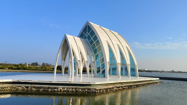 Modern architectural chapel sitting gracefully by the water in Tainan, Taiwan.