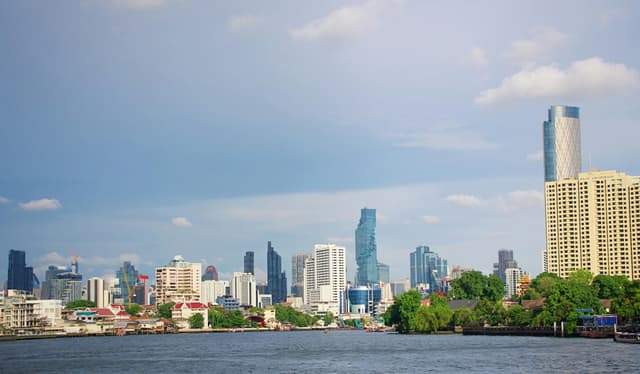 Beautiful view of Bangkok skyline with skyscrapers and river on a sunny day.