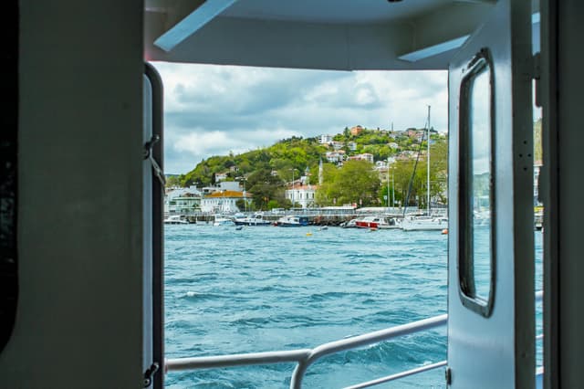 Beautiful coastal view from a ferry in Istanbul showcasing lush hills and vibrant waters.