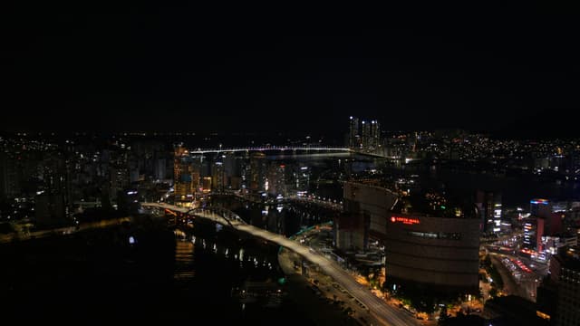A stunning view of Busan skyline at night with Gwangan Bridge illuminating the cityscape.