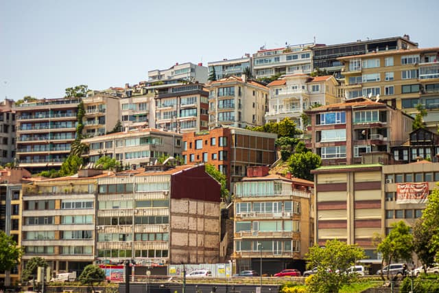 A vibrant collection of hillside apartments with diverse architecture under a clear blue sky.