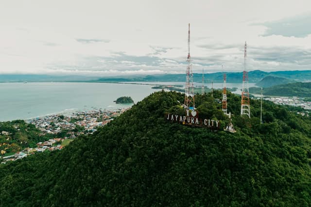 Stunning aerial view of Jayapura City with lush hills and ocean in Papua, Indonesia.