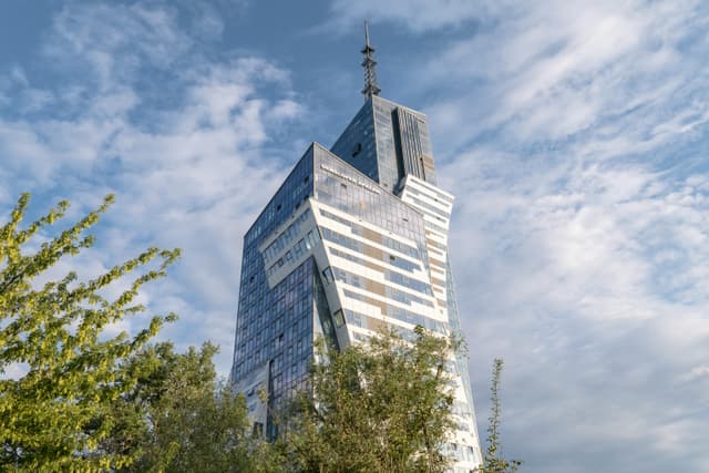 Modern skyscraper with unique design in Rzeszów, Poland. Clear blue skies highlighting the architecture.