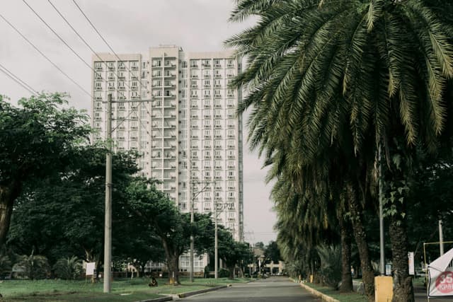 High-rise residence surrounded by tropical trees in Davao City, Philippines.