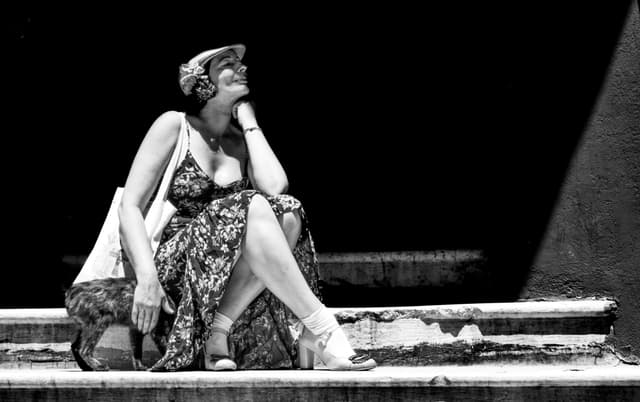 A vintage black and white portrait of a woman sitting on steps in İstanbul, Turkey.