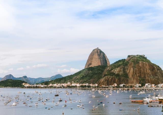 Captivating view of Sugarloaf Mountain in Rio de Janeiro with boats in the bay under a clear sky.