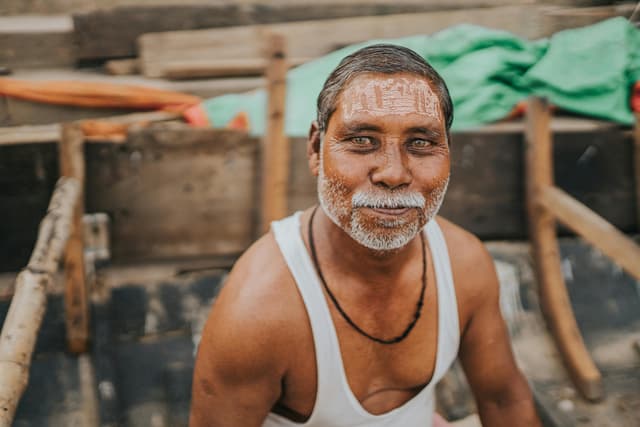 Portrait of a smiling man in a traditional boat in Varanasi, India.