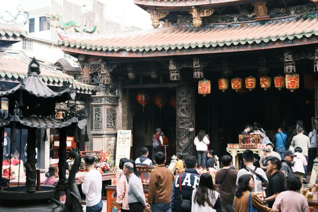 Crowd gathers at a traditional temple in Changhua, Taiwan, celebrating a vibrant cultural festival.