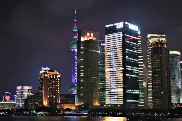 Stunning nighttime view of Shanghai's illuminated skyline featuring the iconic Oriental Pearl Tower.