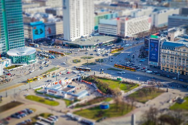 Dynamic aerial view of a busy intersection in Warsaw, showcasing urban life and city structures.