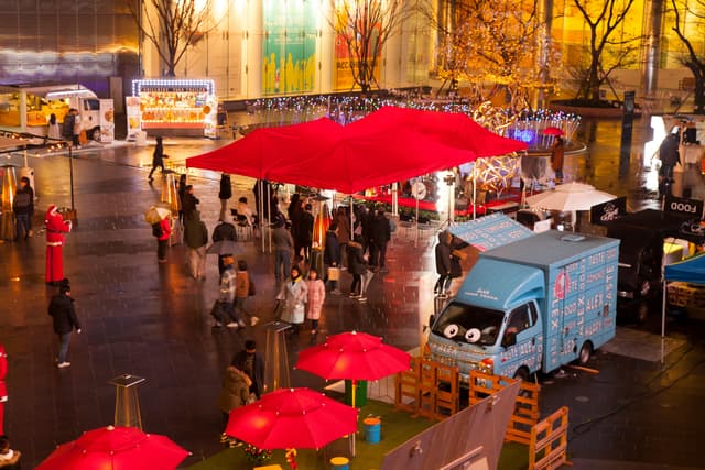 Vibrant Christmas market in Gwangju with food trucks and decorations at night.
