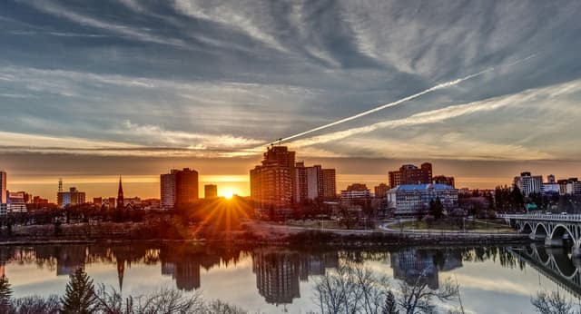 A captivating sunset over a city skyline with vibrant colors reflecting in the river below.