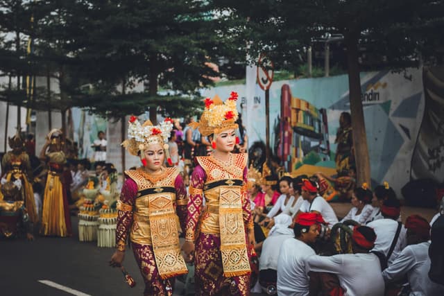 Women in traditional costumes participating in a festival parade in Batam, Indonesia.