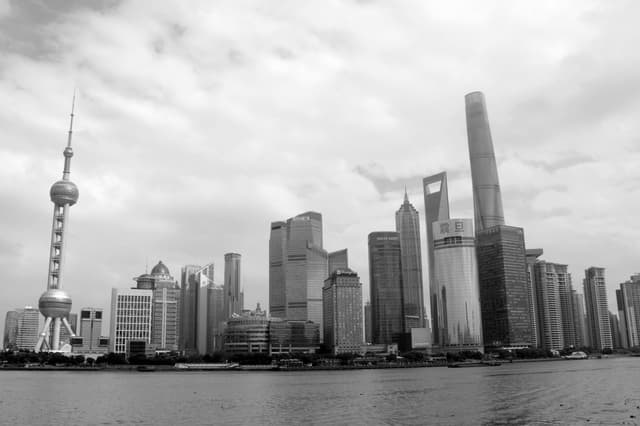 Dramatic black and white skyline of Shanghai's modern Pudong district featuring iconic skyscrapers.