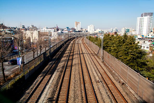 Urban railway tracks in Incheon, South Korea with cityscape view.
