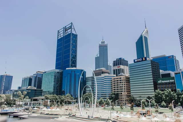 Vibrant skyline of Perth featuring iconic skyscrapers under a clear blue sky.