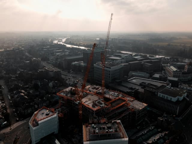Aerial shot of construction cranes and buildings in Kingston upon Thames, England at day.