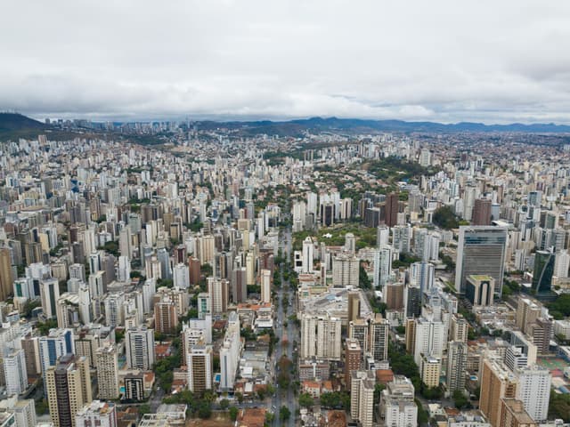 Panoramic aerial view of Belo Horizonte's sprawling urban landscape, showcasing high-rise buildings and residential areas.