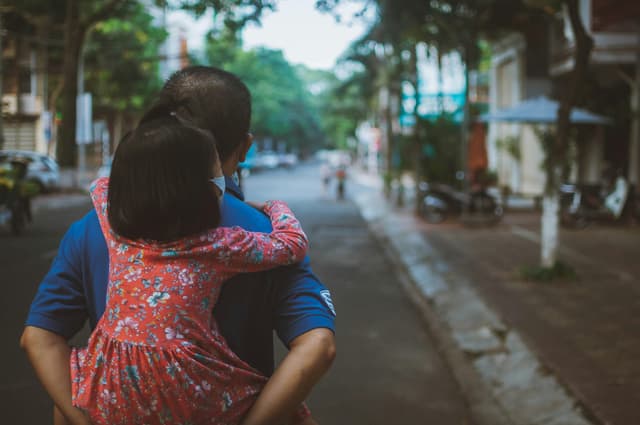 A father carries his daughter on a street in Buon Ma Thuot, Vietnam.