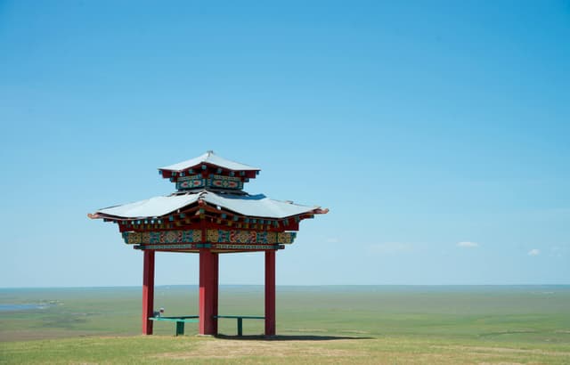 A serene view of a traditional Buddhist pavilion in an open landscape in Kalmykia, Russia.