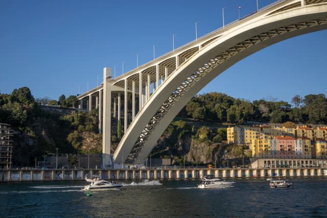 A stunning view of Porto's Arrábida Bridge over the Douro River, showcasing architectural excellence and scenic beauty.